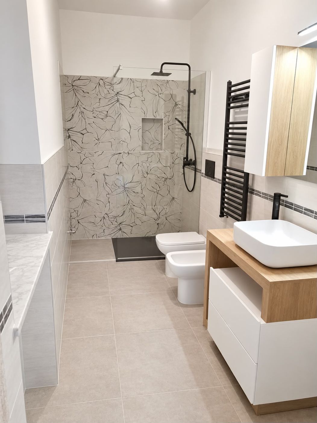 Bagno con doccia walk-in, piastrelle decorate e rubinetteria nera